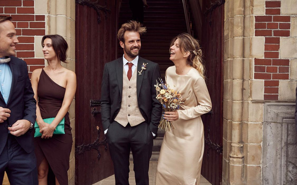Newlywed couple celebrating, groom in a handcrafted Atelier ACÀN suit.