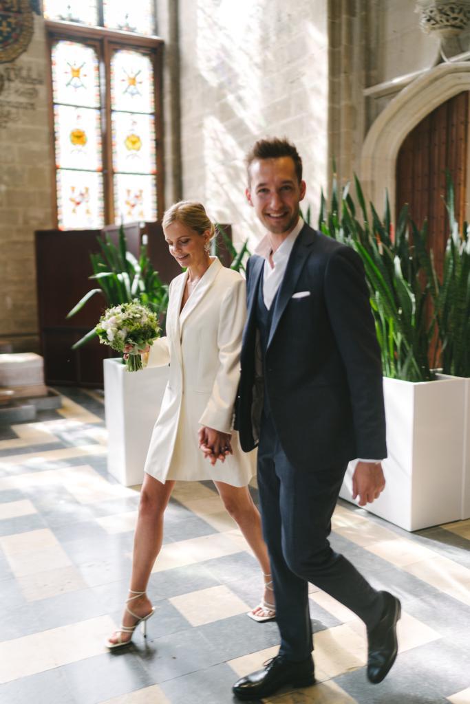 Newlywed couple celebrating, groom in a handcrafted Atelier ACÀN tuxedo.