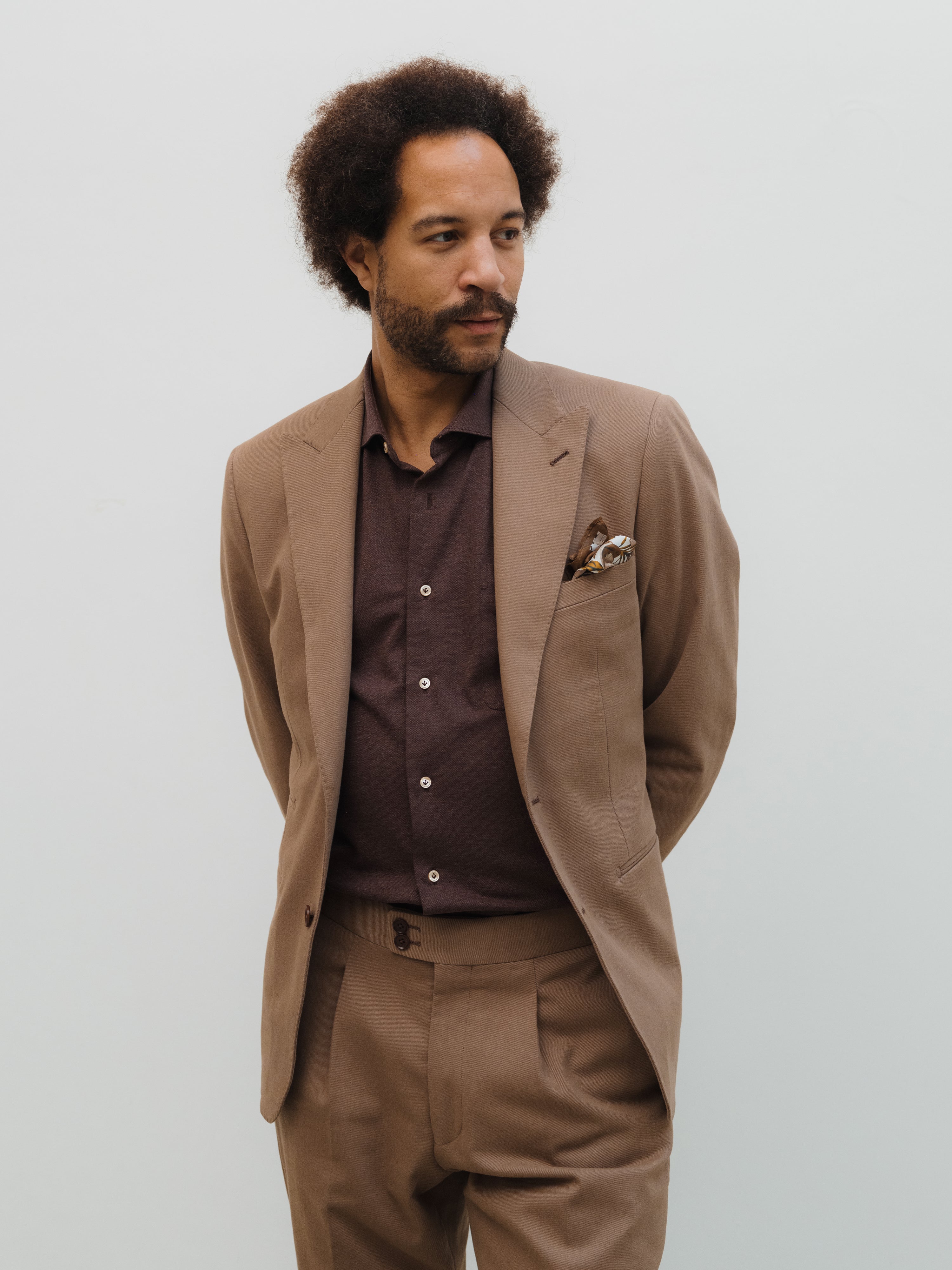 Custom-made suits in rich textures and shades, crafted with precision at Atelier ACÀN in Antwerp and Ghent.