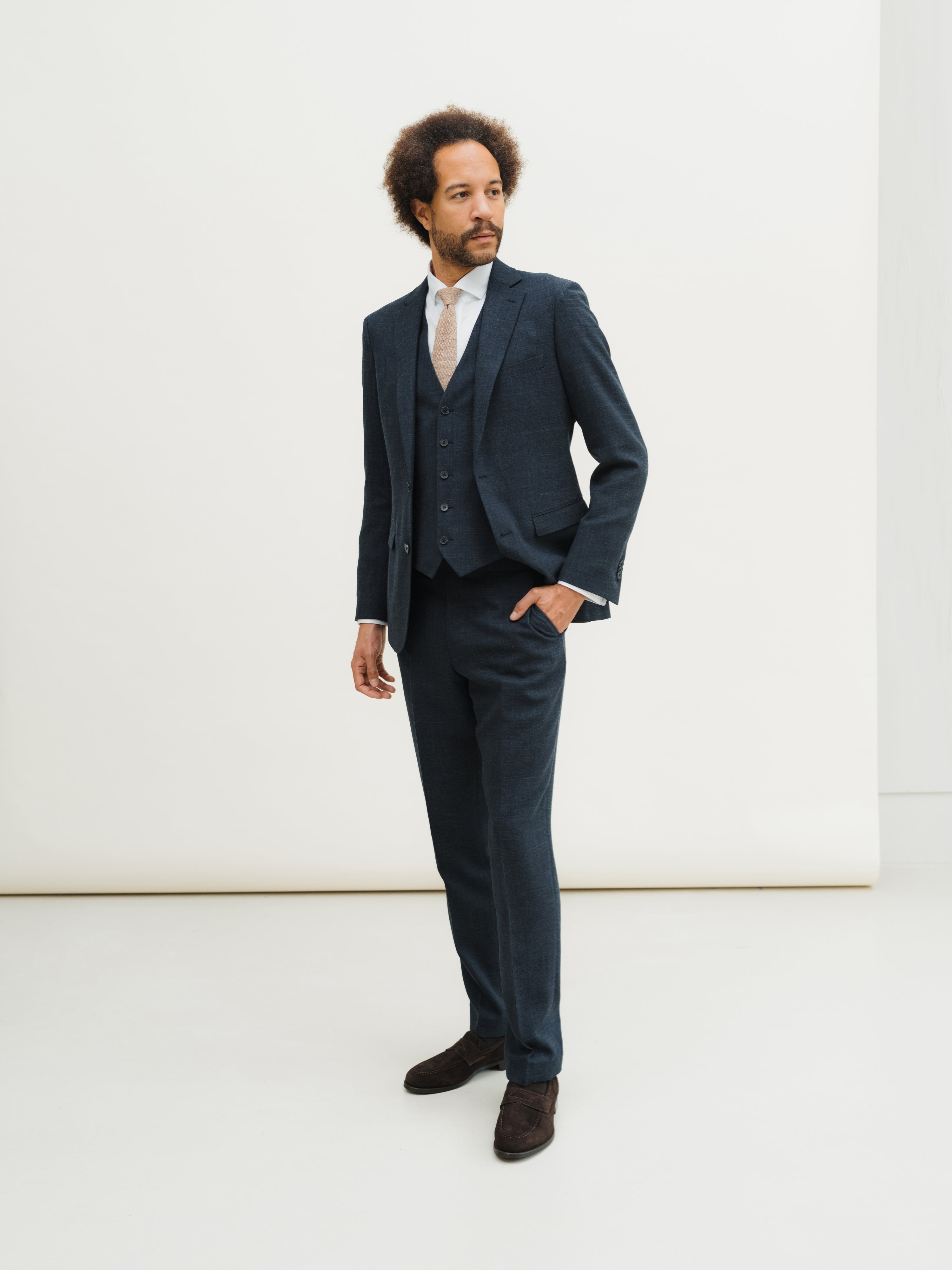 Custom-made suits in rich textures and shades, crafted with precision at Atelier ACÀN in Antwerp and Ghent.