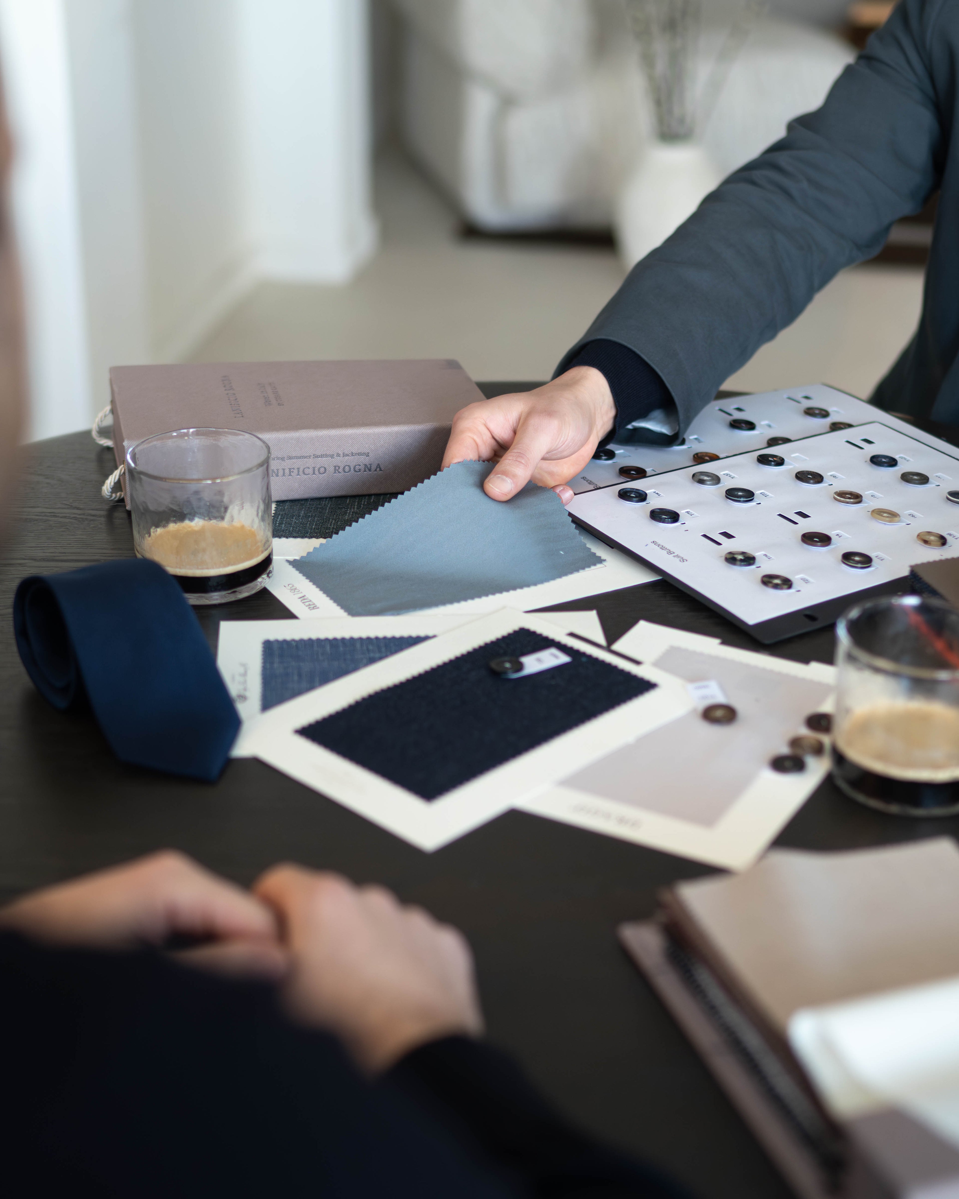 Choosing fabrics and buttons for the perfect tailored suit of our clients.