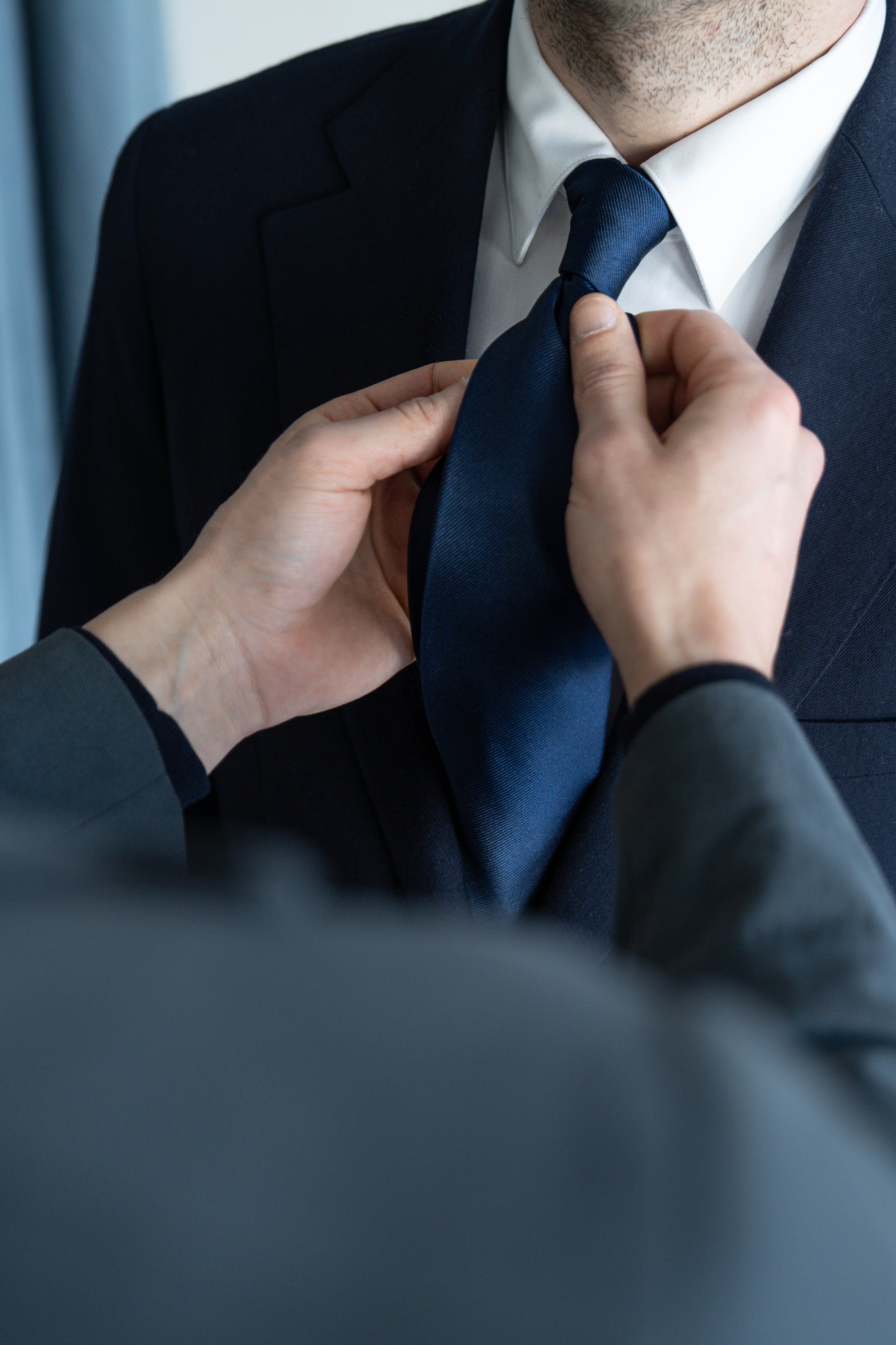 Perfecting the look: Our tailor carefully selects and styles the perfect tie to complement the client’s outfit.