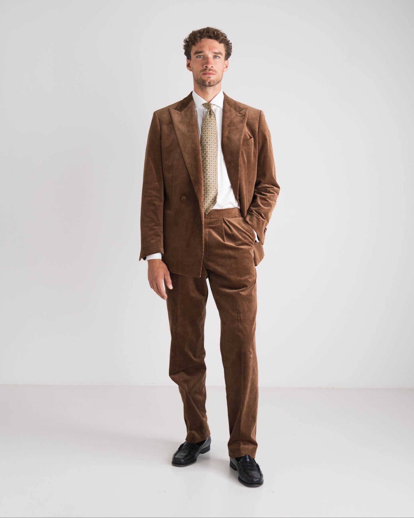 Man wearing a brown suit with a white shirt and tie on a white background