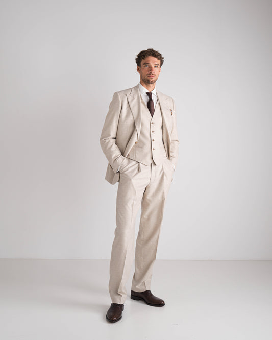 Man in beige drie delig kostuum met bruine das