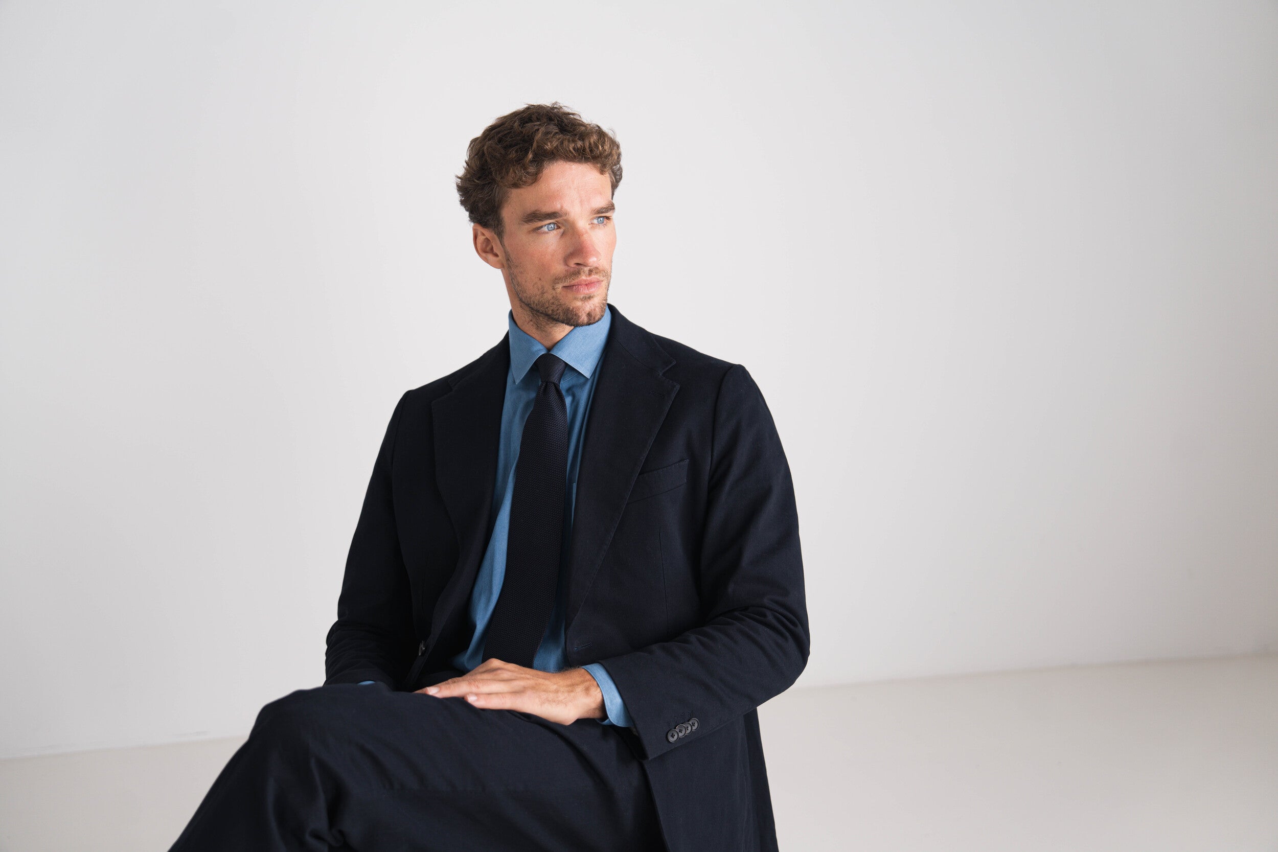 Man in blauw kostuum met blauw hemd en blauwe das.