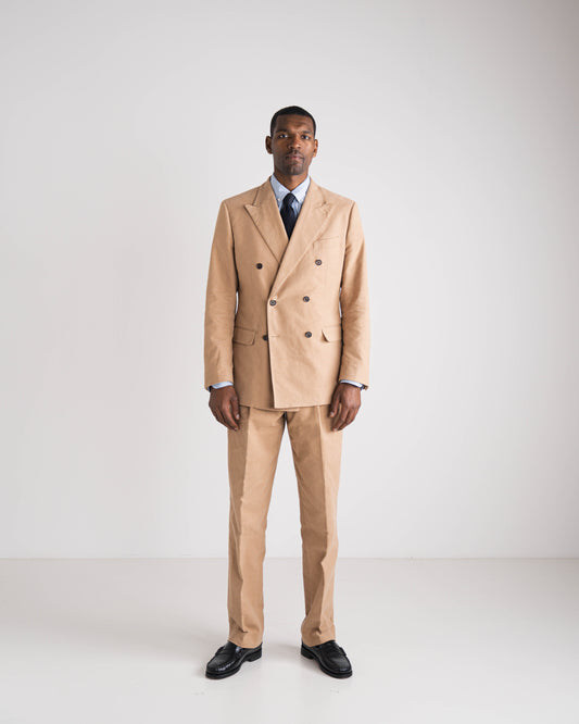 man in camel double breasted kostuum met blauwe das