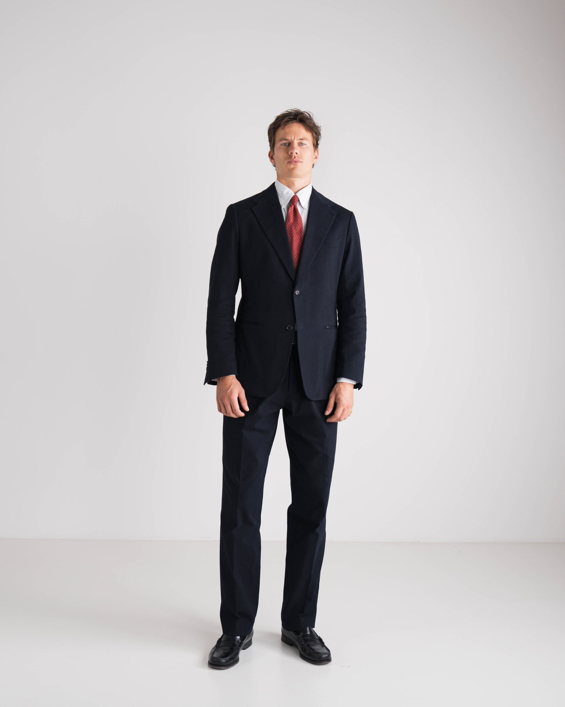 man in blauw kostuum met rode das
