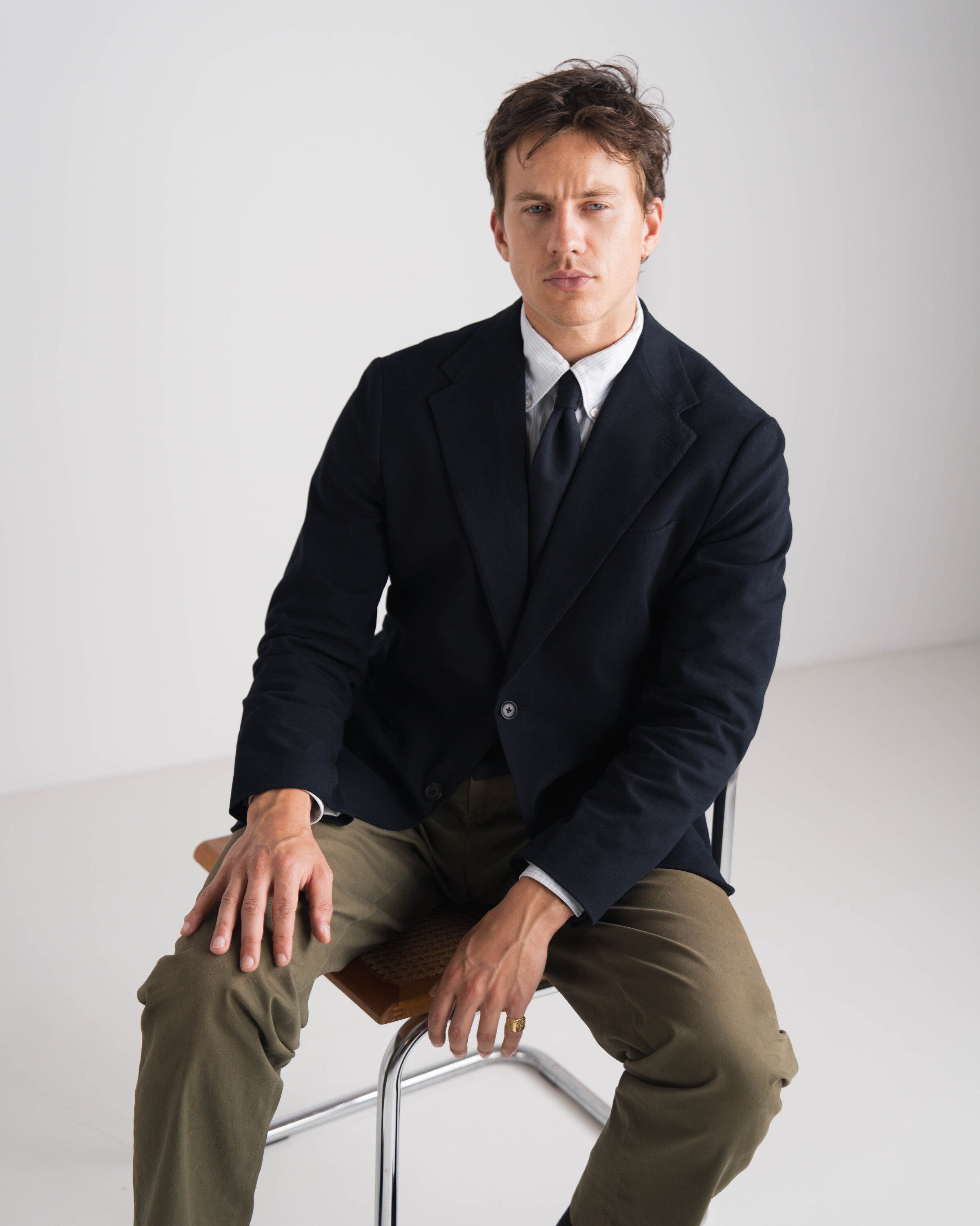 man met groene broek en blauwe blazer en blauwe das