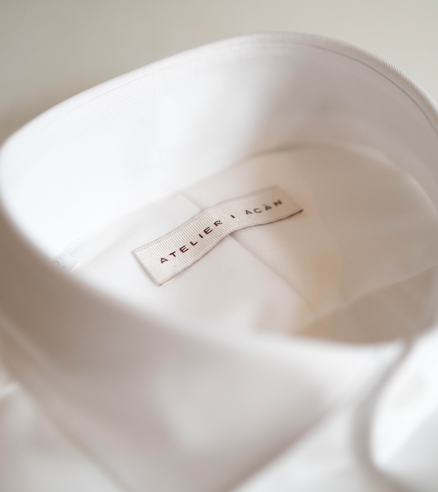 Atelier ACÀN label detail in white dress shirt - quality brand for bespoke suits